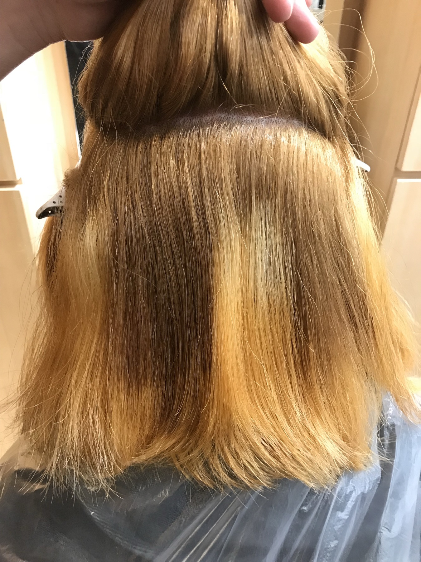 Client A before blonde colour correction, showing uneven warm banding through the hair